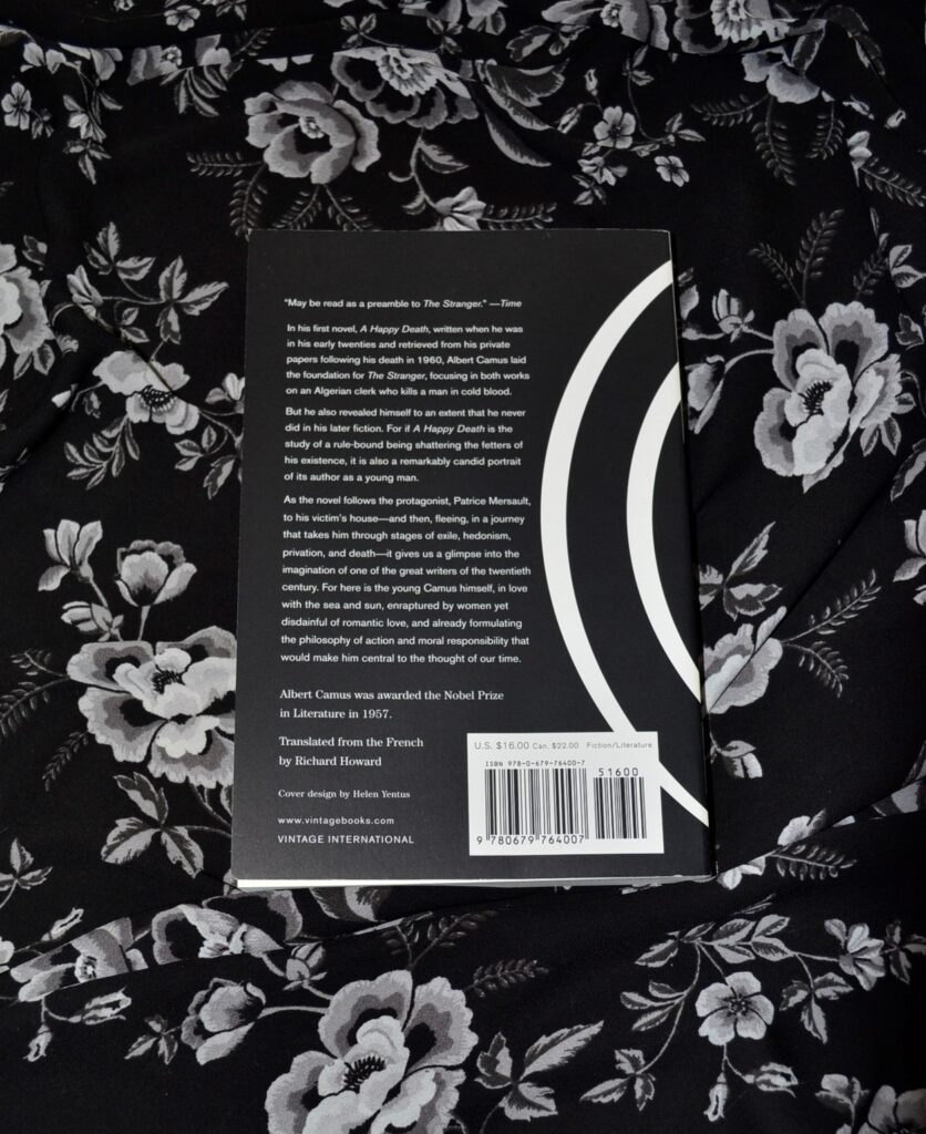 The back cover of A Happy Death on a black and white floral background.