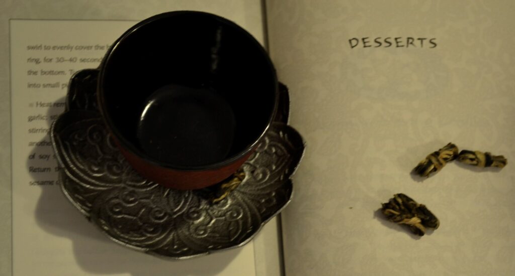 A teacup resting on a page of A Banquet for Hungry Ghosts