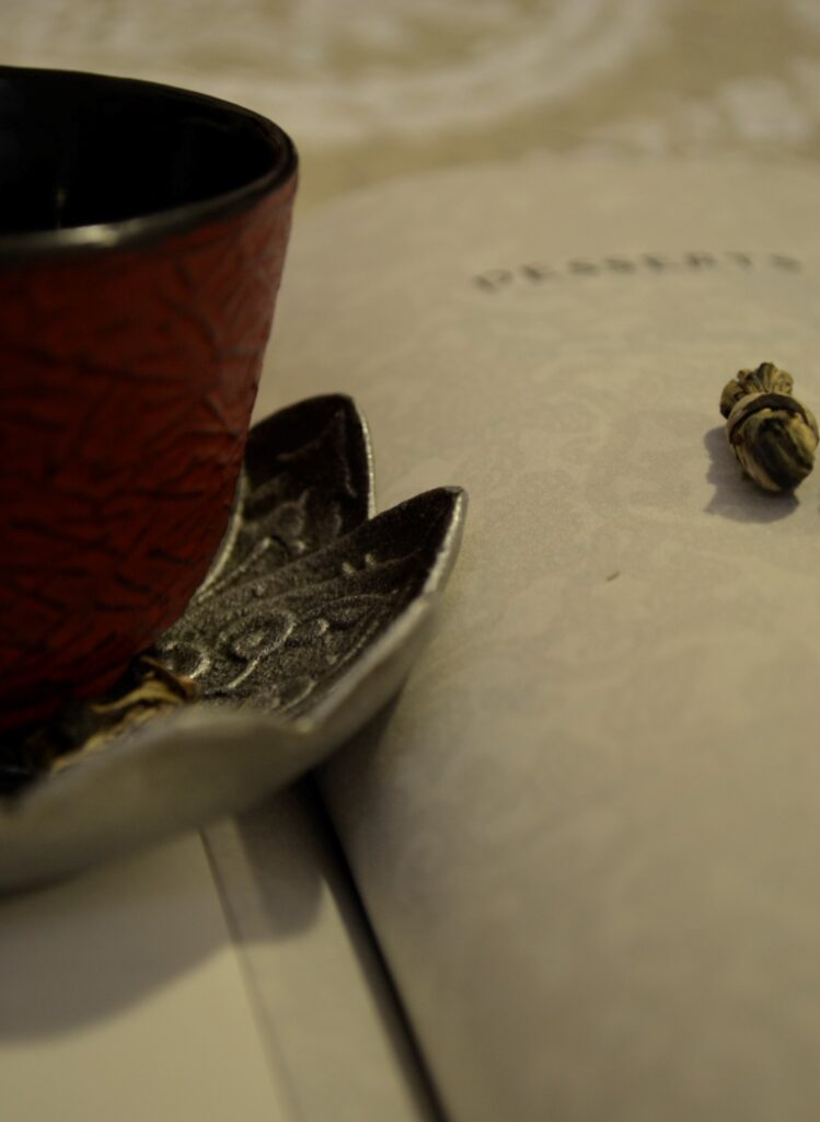 A teacup resting on a page of A Banquet for Hungry Ghosts