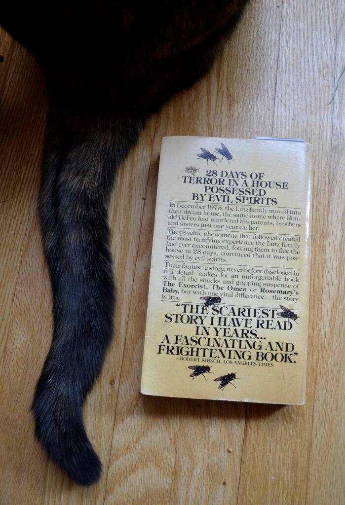 A dark tail flicks beside the back cover, illustrated with flies.