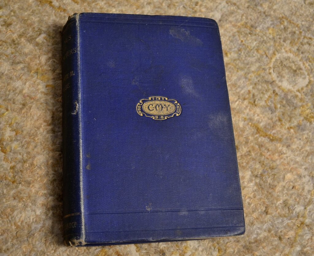 The worn blue cover of Scenes and Characters embossed with the initials of the author.