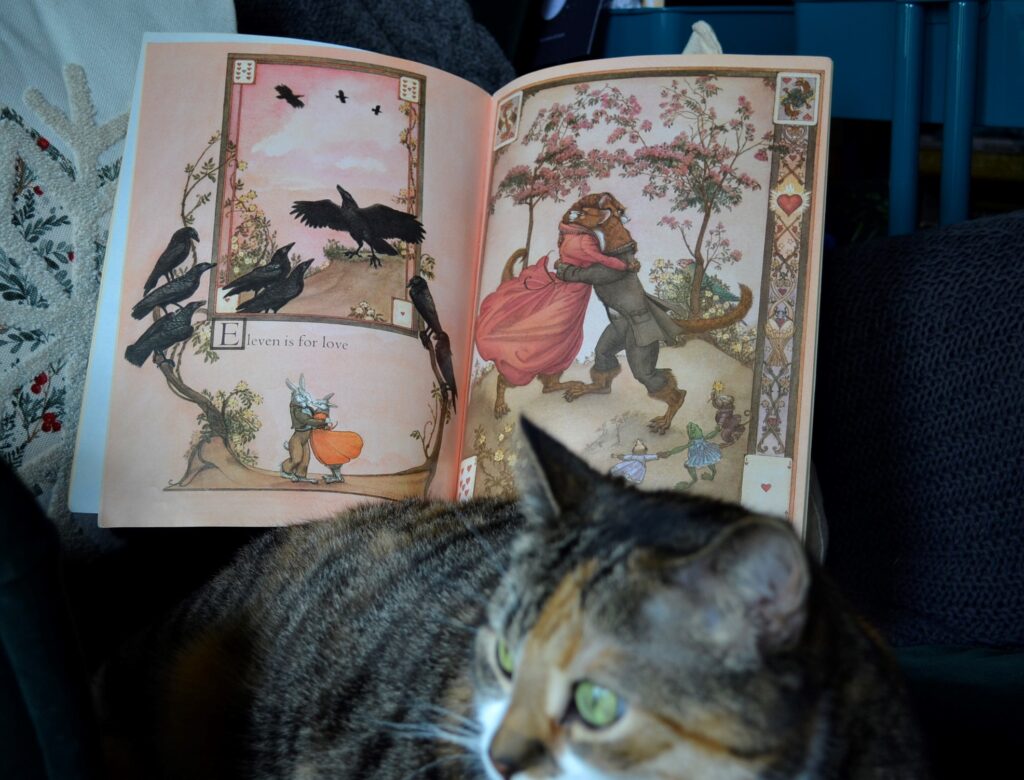 A calico tabby sists in front of the Eleven page in Crows.