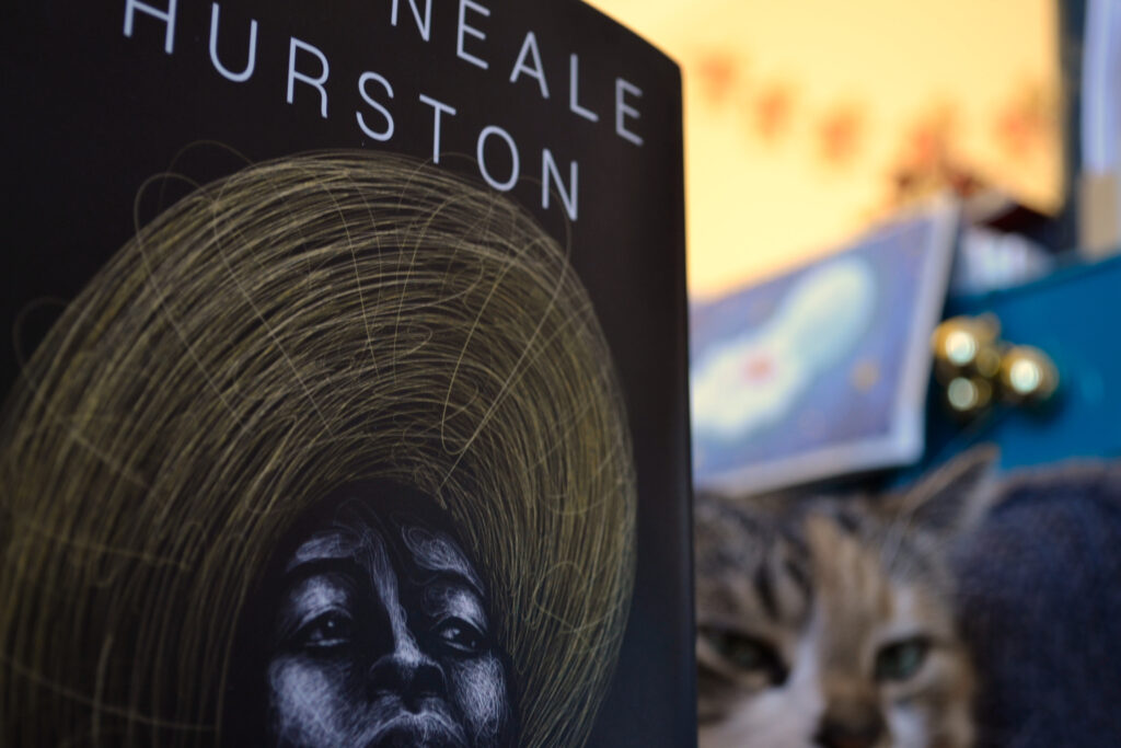 A close-up of a book. The only visible words are 'Neale Hurston' above a pair of eyes that look out to the distance.