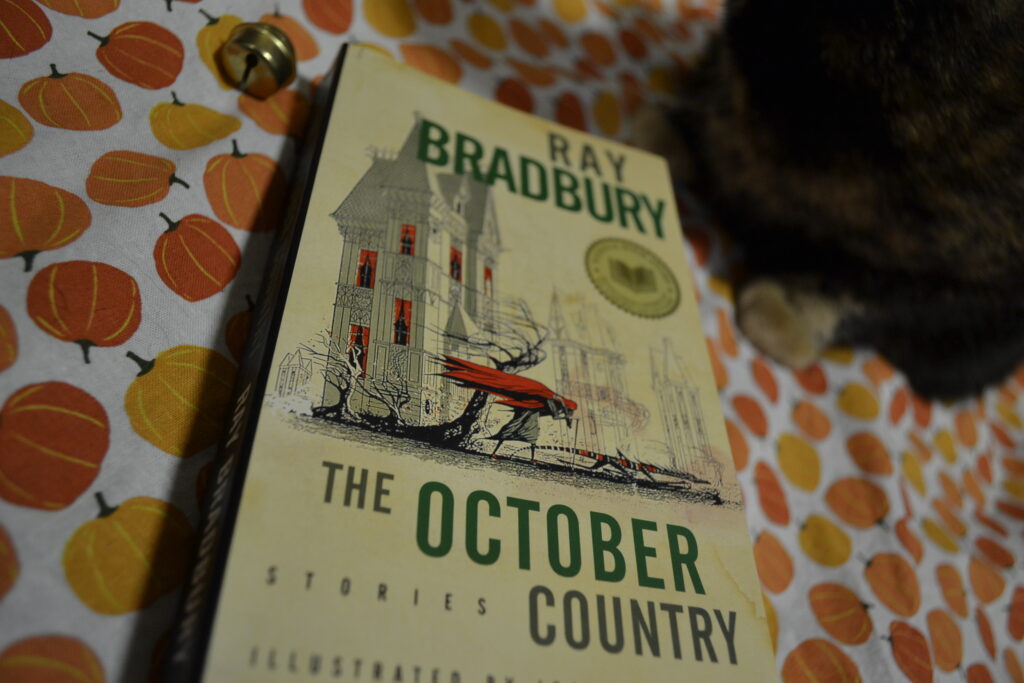 Ray Bradbury's The October Country has a picture of a person in a cape and a lizard-creature straining against the wind.