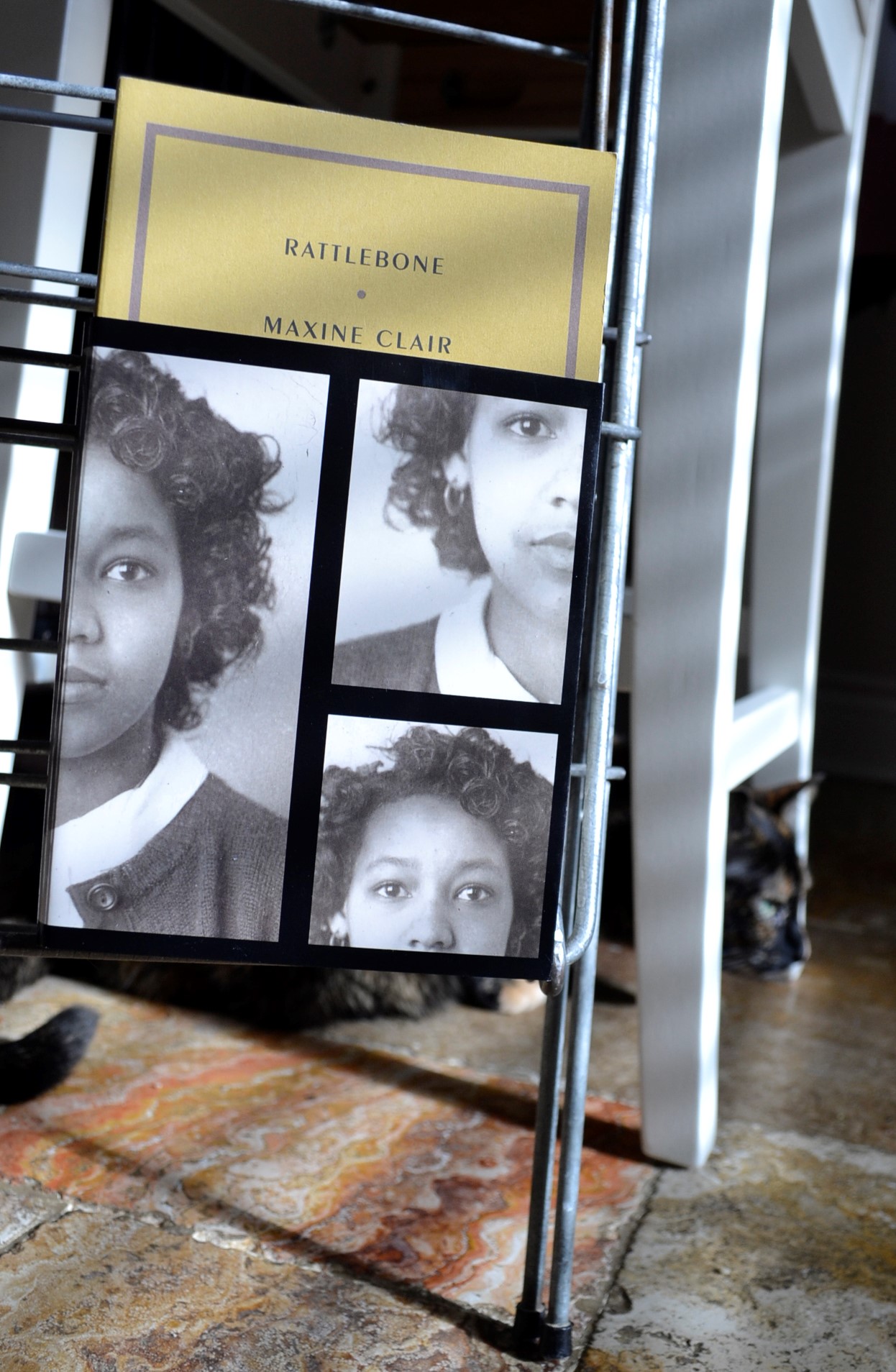 Maxine Clair's Rattlebone is a yellow book with a 3/4 height dust jacket featuring a young Black woman.