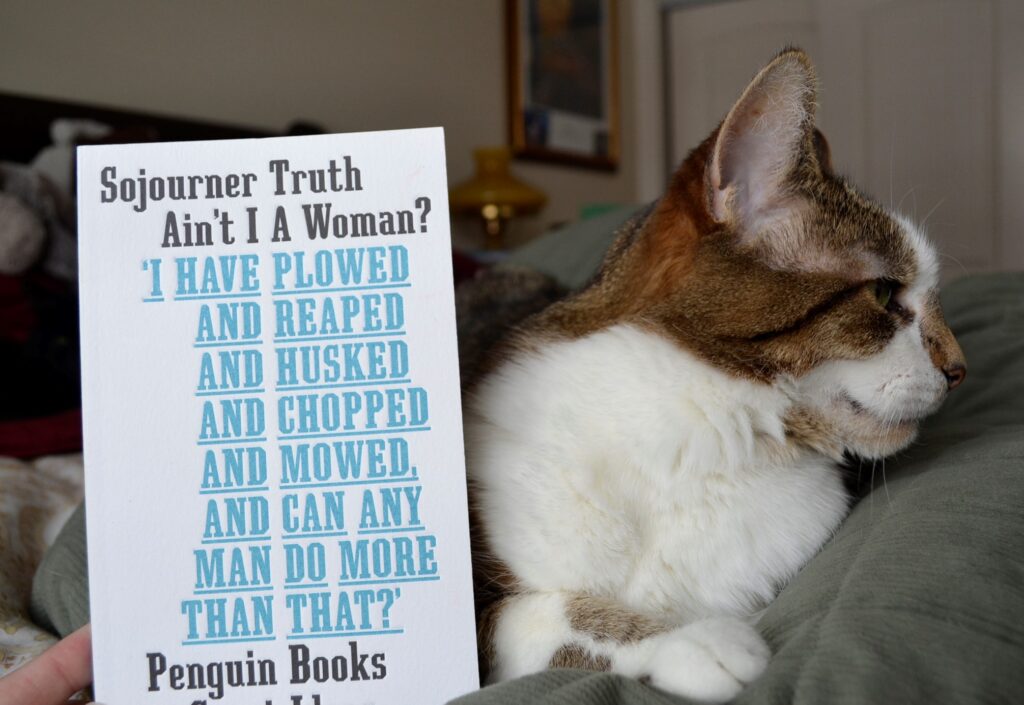 A book by Sojourner Truth has text on the cover: Ain't I a Woman? I have plowed and reaped and husked and chopped and mowed and can any man do more than that?