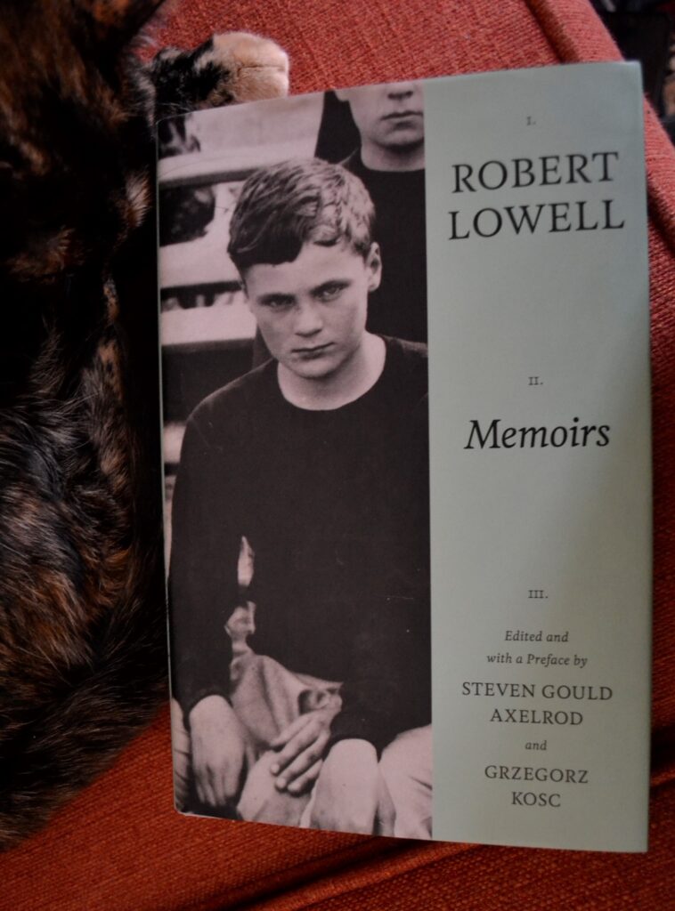 A copy of Robert Lowell's Memoirs lies beside a cat. The book was edited by Steven Gould Axelrod and Gregorz Kosc.