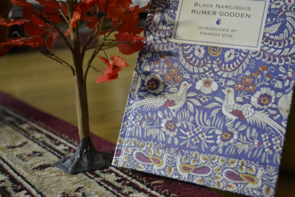 A blue book with embroidery-style motifs has images of flowers and birds upon its cover.