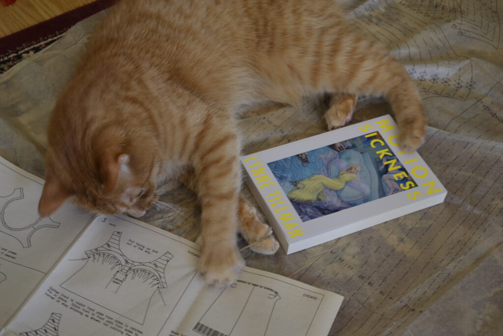 Lynne Tillman's Motion Sickness is a white book with neon yellow text on the cover and a painting of a blonde woman in a yellow dress lounging on a bed.