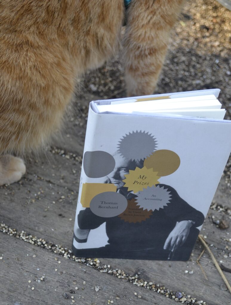 My Prizes by Thomas Bernhard is a little white hardcover book with a picture of Bernhard on the cover, partially obscured by gold, silver, and bronze circles - the kind that usual frame award announcements on book covers.
