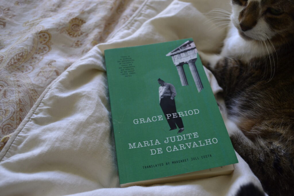 Grace Period by Maria Judite de Carvalho is a green paperback book. On the cover are two grayscale photos of a person and a building that have been trimmed oddly and are missing pieces.